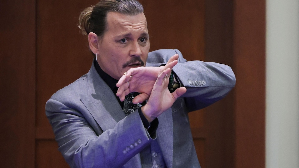 Johnny Depp, les bras près du corps, dans la salle d'audience.