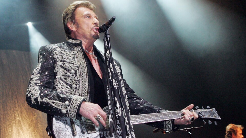 Johnny Hallyday, avec sa guitare, offre une prestation musicale à l'Olympia de Paris en décembre 2006.