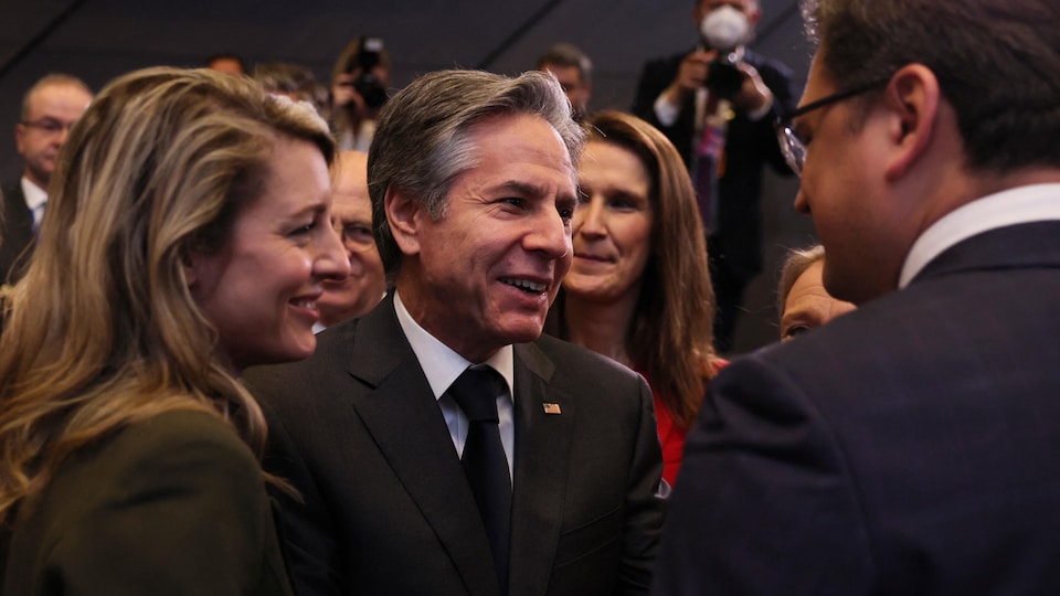 Mme Joly et M. Blinken, en discussion avec M. Kouleba dans une salle.