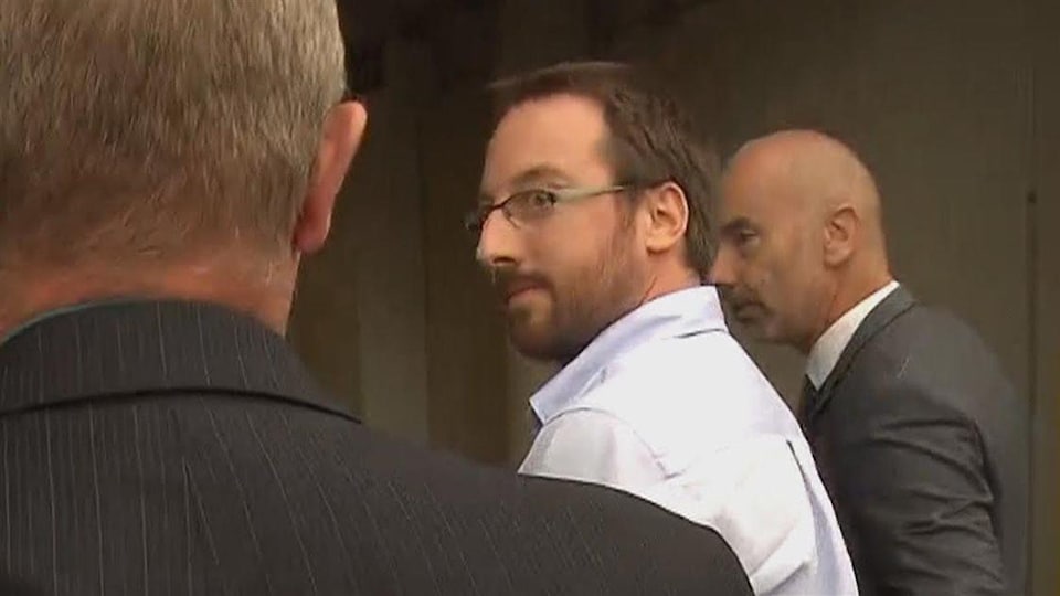 Jonathan Bettez escorté par deux policiers à son arrivée au palais de justice de Trois-Rivières en août 2016.