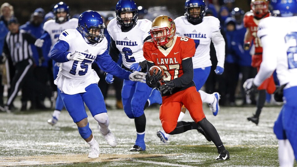 Jonathan Breton-Robert court avec le ballon entouré de joueurs des Carabins.