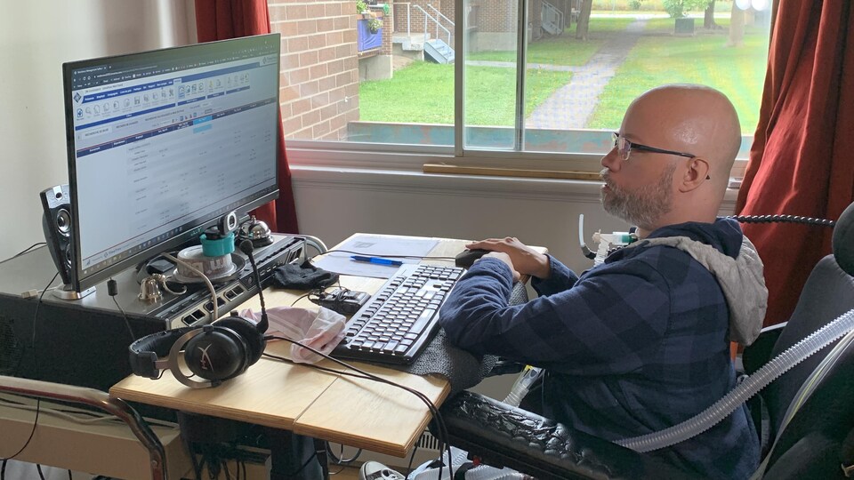 Jonathan Marchand assis devant un ordinateur.