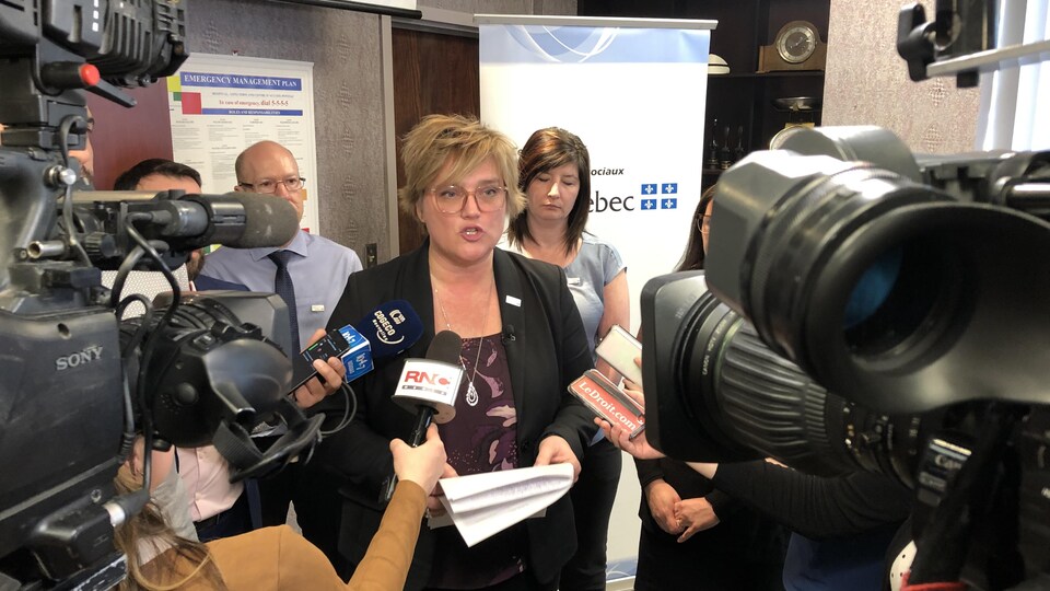 Josée Filion entourée de caméras lors d'un point de presse.