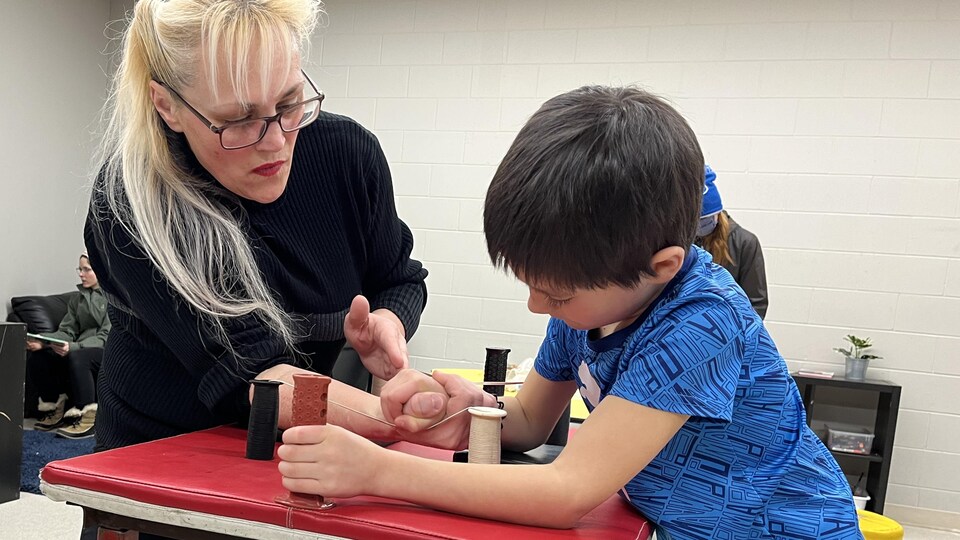 Josée Morneau entraîne un jeune à l'École Précieux-Sang de Winnipeg, lors d'un atelier de tir au poignet, le 26 janvier 2023. 