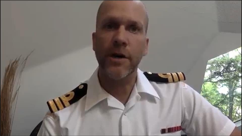 Un homme avec un uniforme naval parle à la caméra.