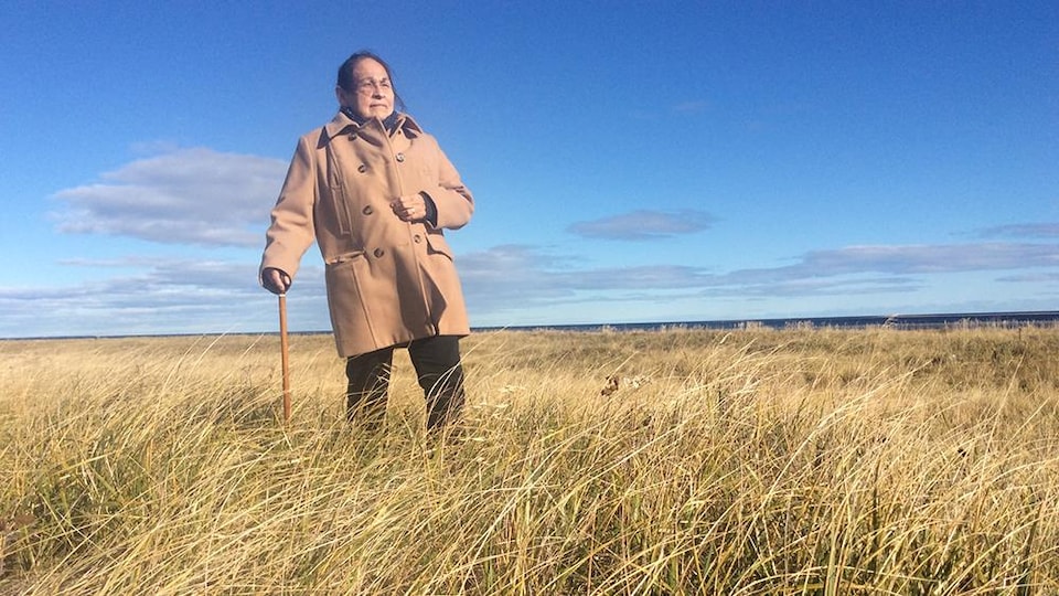Joséphine Bacon se tient au milieu d'un terrain vague.