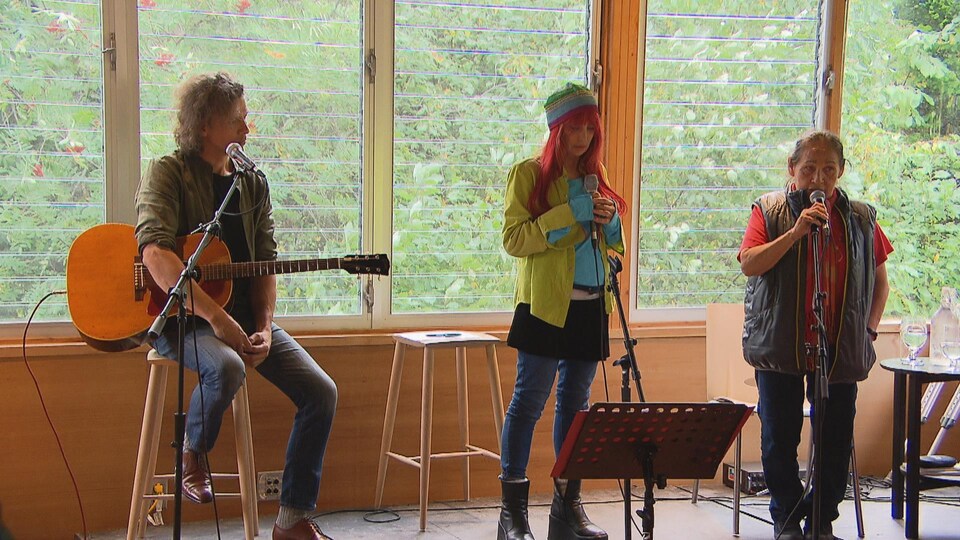 Un guitariste, Chloé Sainte-Marie et Joséphine Bacon sur scène.