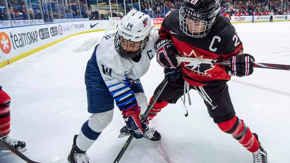 Des joueuses de hockey en pleine action.