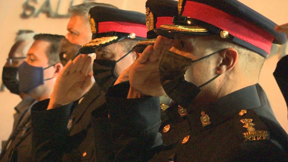 Des policiers font un salut.