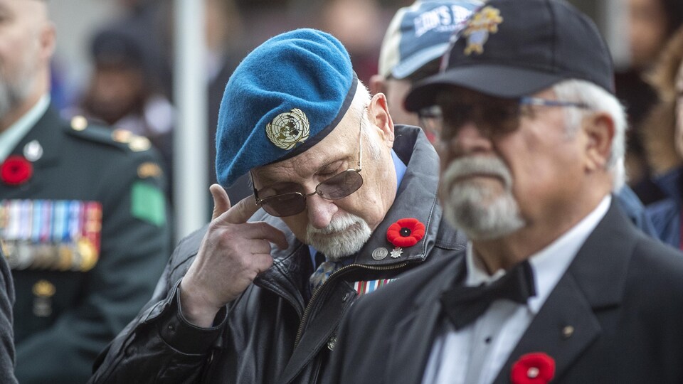 Un homme en uniforme essuie une larme.