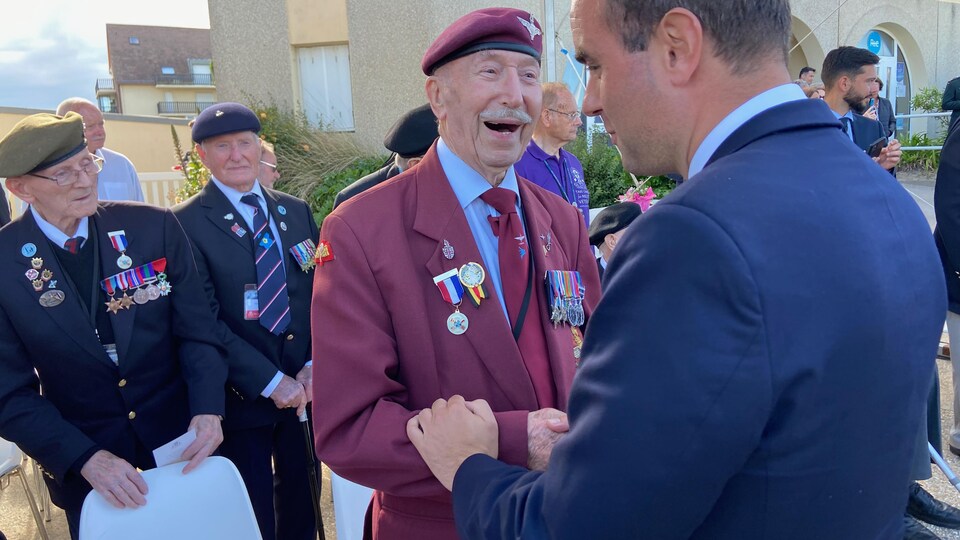 An elderly veteran shook hands with French Minister of the Armed Forces Sébastien Lecornu.
