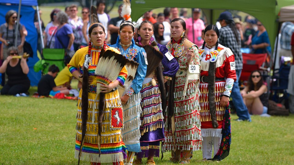 Des adolescentes en tenue traditionnelle sur la pelouse du parc.