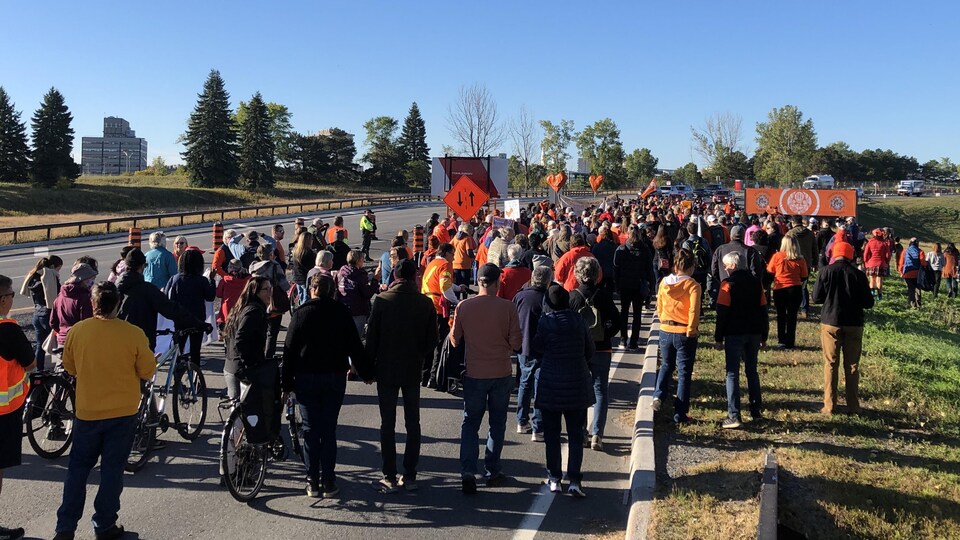 Près de 200 personnes marchent sur la promenade à Ottawa.