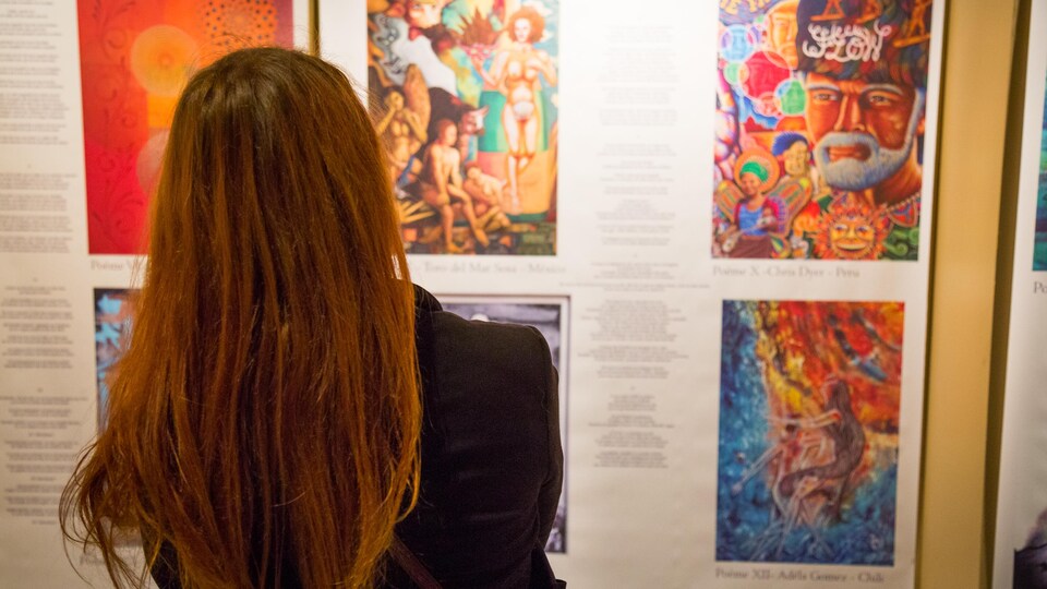 Une femme observe des oeuvres d'art.