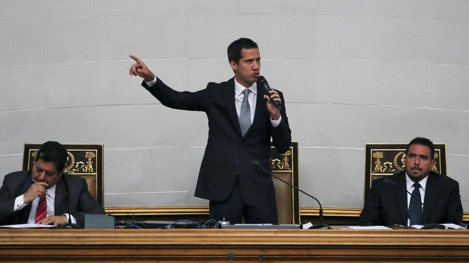 Juan Guaido est debout et parle dans un micro.