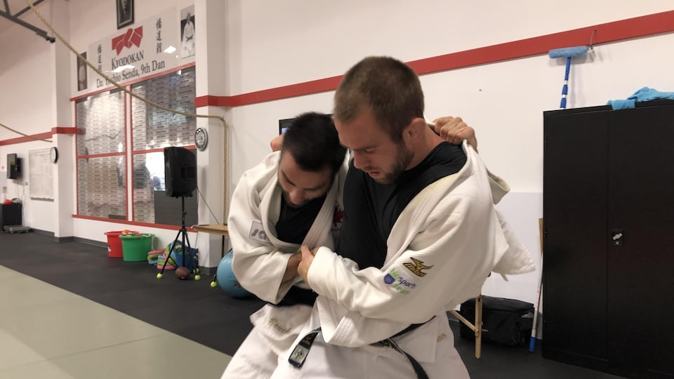 Deux judokas s'attrapent l'un l'autre et essaient de se faire tomber.