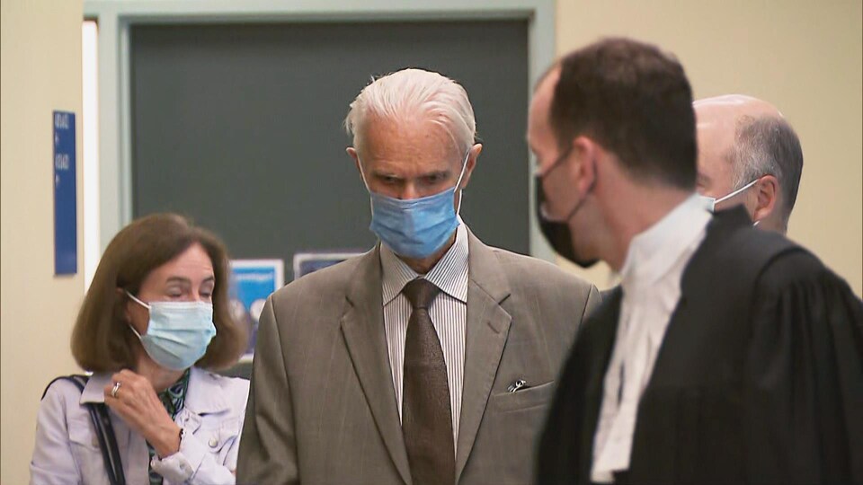 The judge looked down and wore a surgical mask.  He was surrounded by his lawyers as well as a relative. 