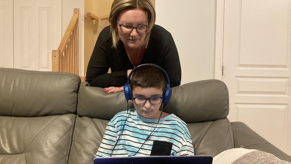Julie Bouchard regarde son fils Arthur jouer à l'ordinateur.