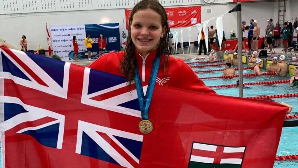 Julie Brousseau avec sa médaille et le drapeau de l'Ontario.