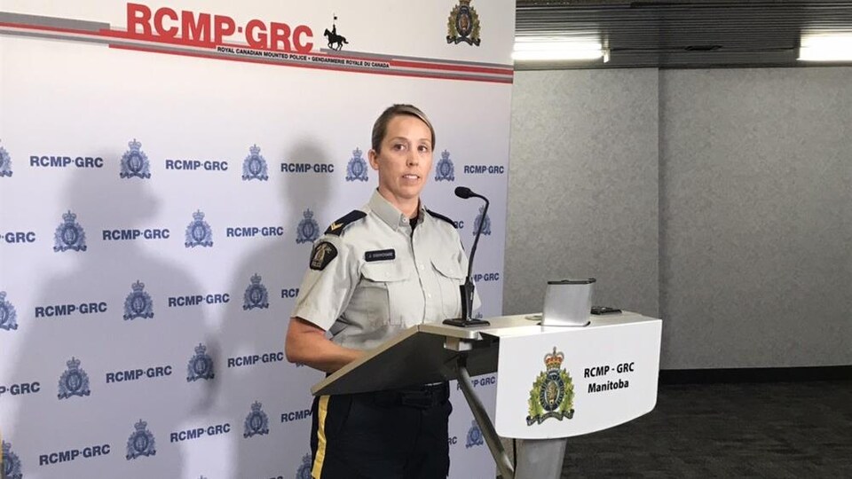 Une femme blonde devant un panneau RCMP-GRC.