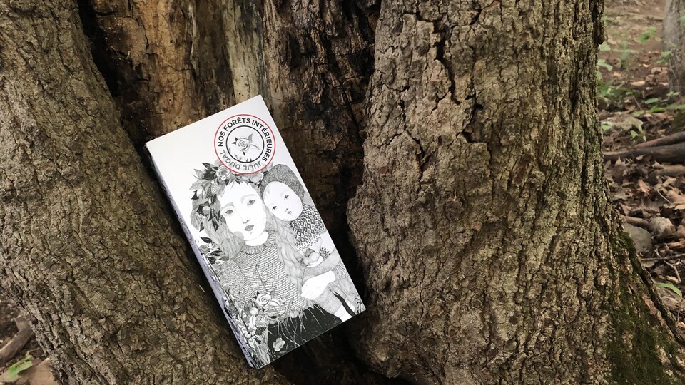 Le roman est posé dans un genre de trou à la base d'un tronc d'arbre. Sur la couverture blanche, la gravure en noir et blanc présente une femme tenant un enfant sur sa hanche de son bras gauche.