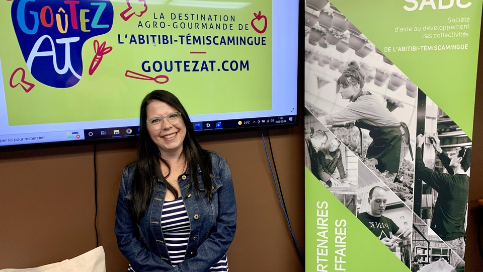 Julie Gauthier devant une présentation de Goûtez AT dans un écran de télévision lors d'une conférence de presse.