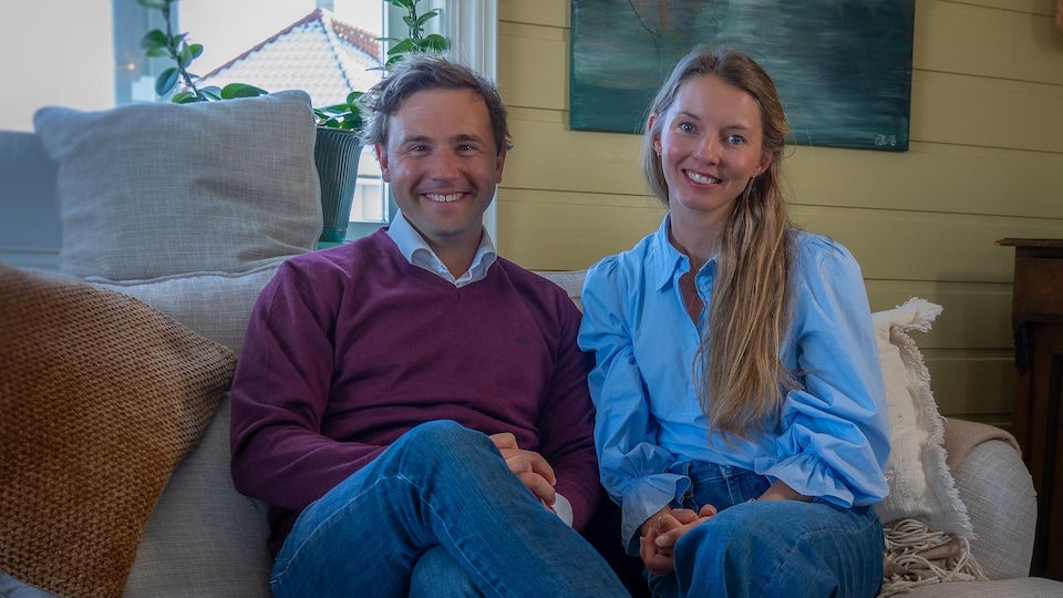 Julien Bourelle et Elise Kollerud assis sur un canapé, souriant à la caméra.