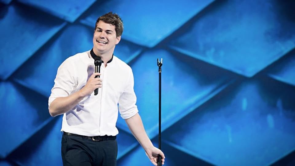Julien Lacroix tient un micro dans la main droite