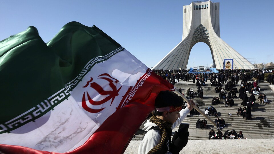Un garçon porte un drapeau iranien devant la Tour Azadi (Liberté) à Téhéran pour marquer le 40e anniversaire de la Révolution islamique. 