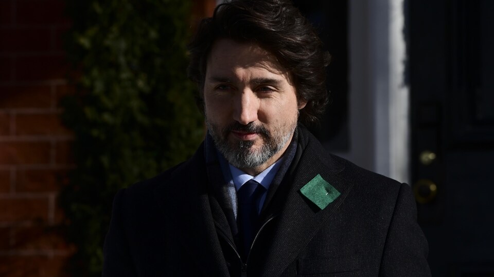 Le premier ministre du Canada se dirigeant vers le micro, à l'extérieur.