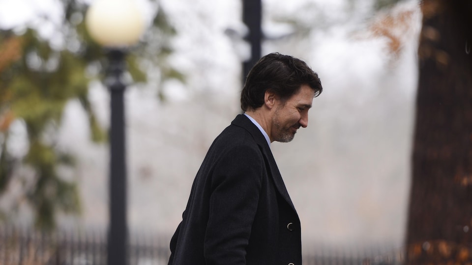 Justin Trudeau, de profil, marche.