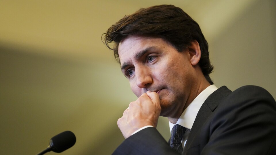 Portrait du premier ministre Justin Trudeau, la main au visage. 
