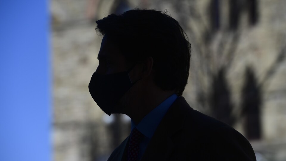 Justin Trudeau, masqué, devant le Parlement.