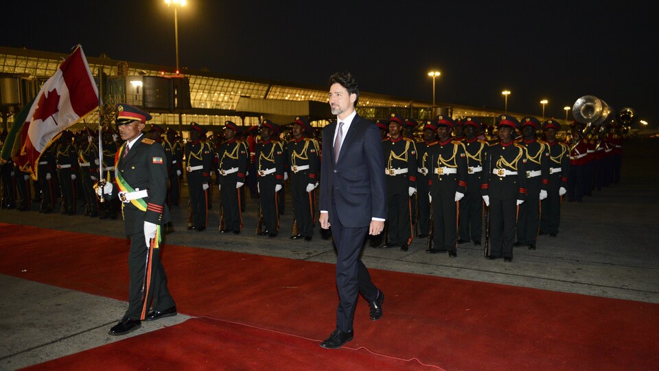 Justin Trudeau marche devant des membres de la garde éthiopienne.