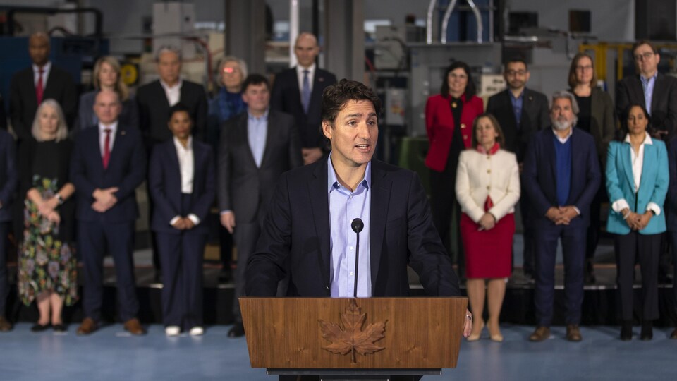 Justin Trudeau en conférence de presse avec ses ministres à l'arrière.