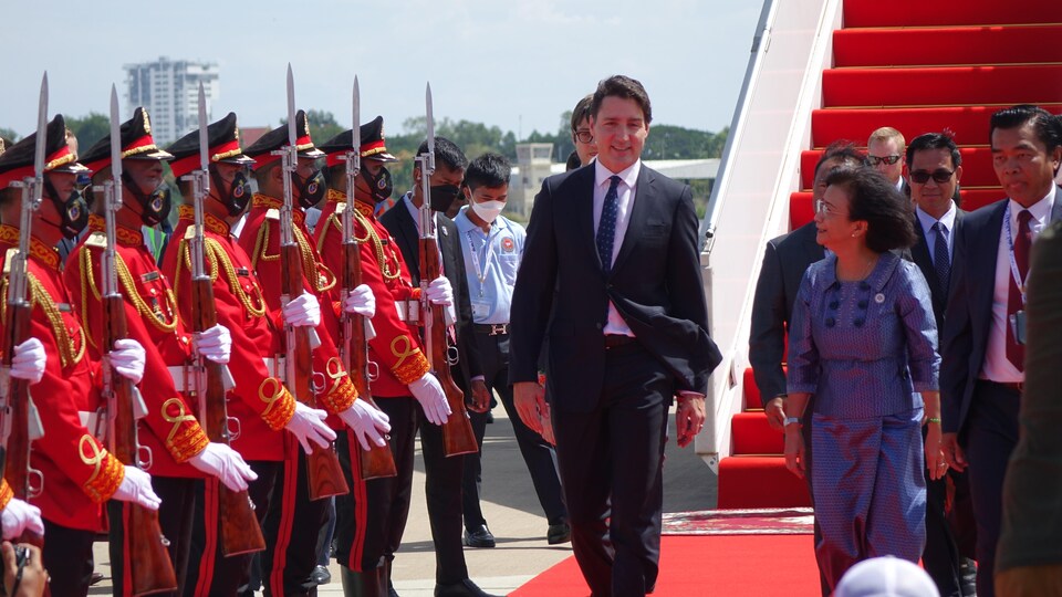 Justin Trudeau marche sur un tapis rouge à sa descente d'avion au Cambodge.