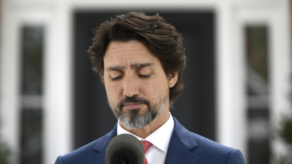 Le premier ministre Justin Trudeau marque une pause en fermant les yeux durant un point de presse.
