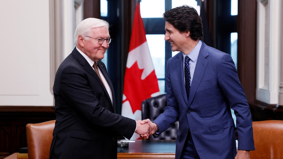 The two men shake hands.