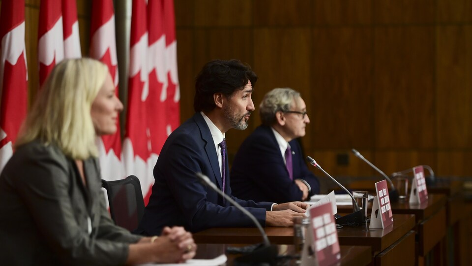 Justin Trudeau, en conférence de presse, avec Catherine McKenna et Michael Sabia.