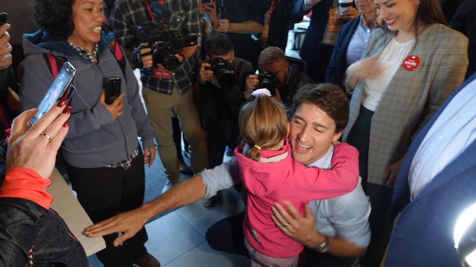 Justin Trudeau reçoit un câlin d'une fillette.
