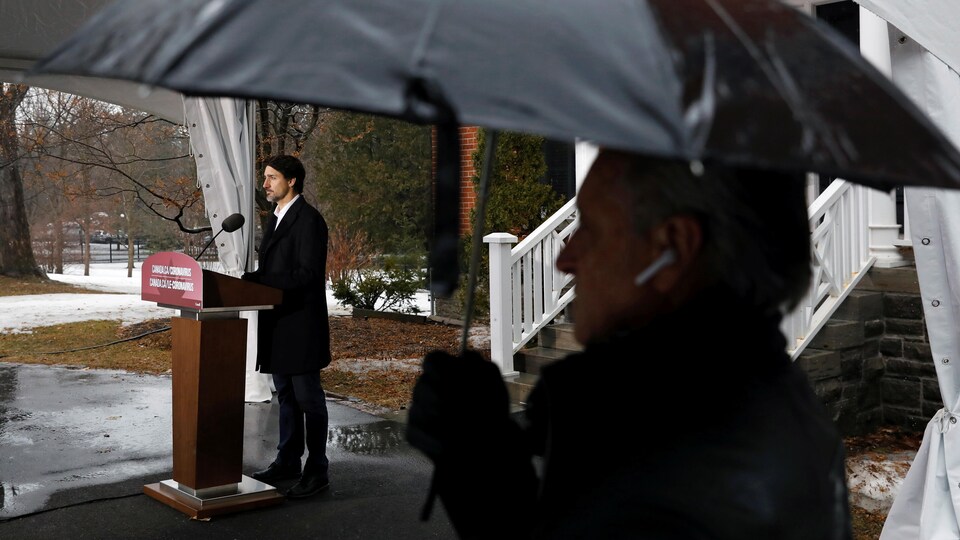 Justin Trudeau en conférence de presse à l'extérieur.
