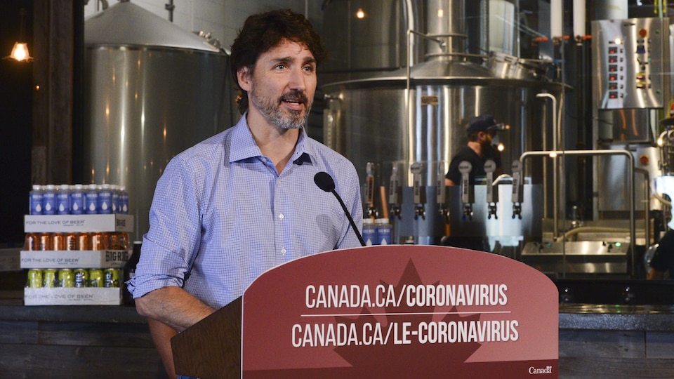 Le premier ministre Justin Trudeau, debout, durant une conférence de presse dans une brasserie ontarienne.