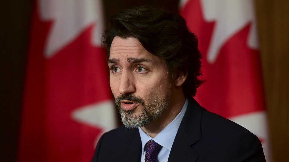 Le premier ministre du Canada Justin Trudeau, assis, durant une conférence de presse.