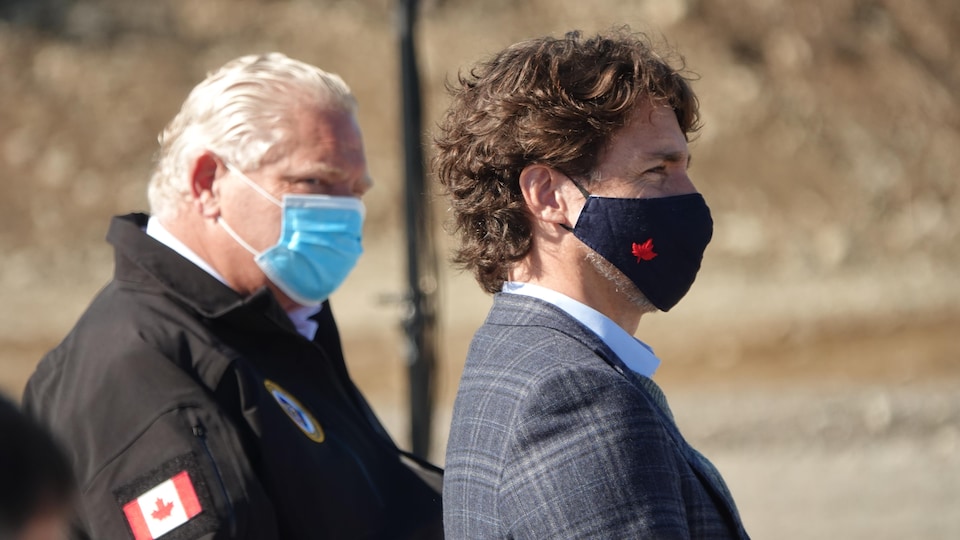 Justin Trudeau et Doug Ford sont assis côte à côte portant leur masque.