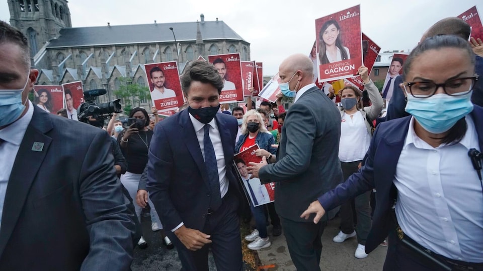 Justin Trudeau passe devant des partisans, entouré de gardes du corps.                               