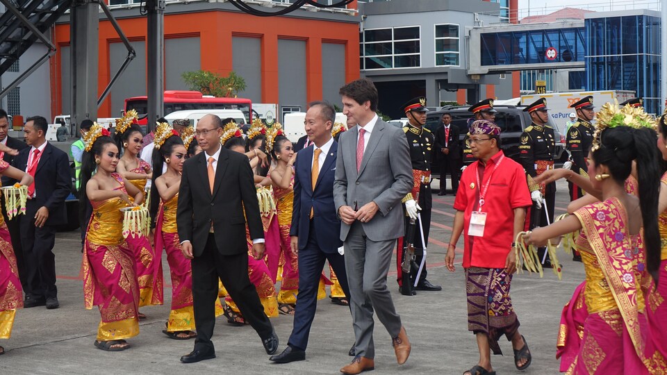 Justin Trudeau marche à Bali avec des dignitaires et des femmes les accueillent en dansant avec des habits traditionnels. 