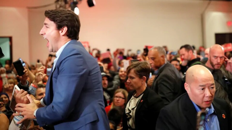 Justin Trudeau avec un gilet pare-balles sous ses vêtements lors d'un rassemblement.