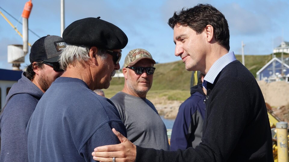 Justin Trudeau parle avec des pêcheurs. 