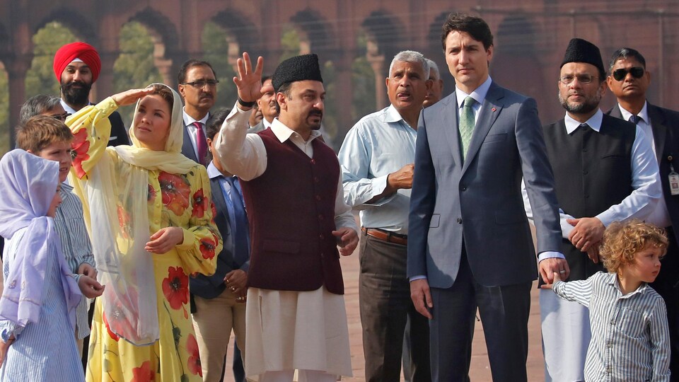 Justin Trudeau et sa famille sont entourés d'Indiens qui leur font visiter un site.