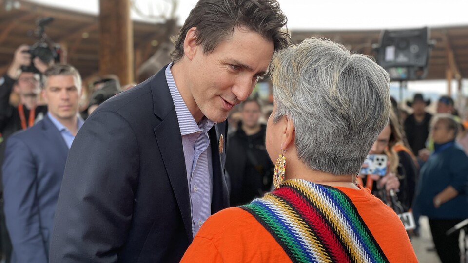 Prime Minister Justin Trudeau spoke to a woman in an orange dress.